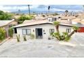 Home exterior featuring xeriscaping, a mature palm tree, a long driveway, and mountain views at 3037 Holly Hill Ave, Las Vegas, NV 89104