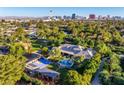 Expansive estate featuring a pool, sport court, lush greenery, and city views in the distance at 330 Rancho Cir, Las Vegas, NV 89107