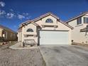 Home featuring a spacious two-car garage, desert landscaping, and a neutral color scheme at 3512 Trilogy Dr, Las Vegas, NV 89108