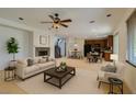 Inviting living room featuring a fireplace, ceiling fan, and open floor plan with lots of natural light at 3809 Alpine Track Ave, North Las Vegas, NV 89032