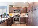 Modern kitchen featuring stainless steel appliances, dark wood cabinets, and sleek countertops at 4129 Chamisa Cove St, Las Vegas, NV 89115