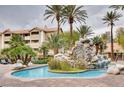 Community pool area with rock waterfall and lounge chairs, surrounded by palm trees at 4200 S Valley View Blvd # 3078, Las Vegas, NV 89103