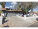 Side view of gray single-story home showing the driveway, garage and white-brick exterior walls at 4509 Paseo Del Ray Dr, Las Vegas, NV 89121