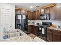 Modern kitchen with stainless steel appliances, granite countertops, and dark wood cabinetry at 4612 Townwall St, Las Vegas, NV 89115