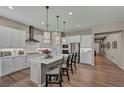 Bright, modern kitchen featuring a large island with seating, stainless steel appliances, and sleek white cabinetry at 6325 Gambetta St, Las Vegas, NV 89115