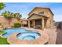 Backyard pool and spa with covered patio and outdoor seating area on a sunny day at 7013 Bisoni St, Las Vegas, NV 89149
