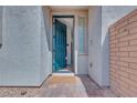 Inviting entryway showcasing a teal front door, brick accents and desert landscaping at 764 Aurora Vale Pl, Henderson, NV 89011