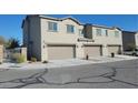 Exterior view of townhomes featuring attached garages and well-maintained landscaping at 806 Star Estates Ave, North Las Vegas, NV 89086