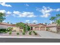 Inviting single-story house featuring a two-car garage, desert landscaping, and an eye-catching vine wall at 8134 Maddingley Ave, Las Vegas, NV 89117