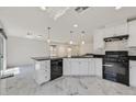 Modern kitchen featuring white cabinets, black appliances, and elegant marble floors at 8755 Spanish Ridge Ave, Las Vegas, NV 89148