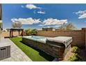 Backyard featuring a swim spa, artificial grass, and a covered seating area at 9638 Smiley Creek St, Las Vegas, NV 89178
