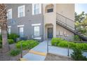 Attractive condo building with lush greenery, a welcoming entrance and a charming stairway at 10245 S Maryland Pkwy # 106, Las Vegas, NV 89183