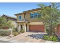 Two-story home with a two-car garage and mature trees, a brick driveway, and desert landscaping at 10693 Harvest Green Way, Las Vegas, NV 89135