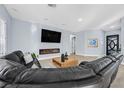 Modern living room with sleek fireplace, hardwood floors, and comfortable seating at 11 Feather Sound Dr, Henderson, NV 89052