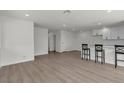 Open-concept living room featuring new laminate floors and a stylish breakfast bar, perfect for entertaining and casual dining at 2504 Paradise Village Way, Las Vegas, NV 89120