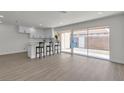 Bright living space with modern white kitchen, bar stool seating, new laminate floors, and sliding glass doors to a private backyard at 2504 Paradise Village Way, Las Vegas, NV 89120