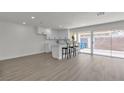 Bright living space with modern white kitchen, bar stool seating, new laminate floors, and sliding glass doors to a private backyard at 2504 Paradise Village Way, Las Vegas, NV 89120
