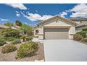 Charming single-story home with desert landscaping, well-maintained lawn, and a gray concrete driveway at 3257 River Glorious Ln, Las Vegas, NV 89135
