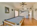 A spacious game room features an elegant pool table, ceiling fan, and gleaming wood floors at 3432 Beca Faith Dr, North Las Vegas, NV 89032