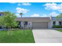Inviting single-Gathering house featuring a lush green lawn, mature trees, and an attached two-car garage at 3667 Mckinley Ave, Las Vegas, NV 89121