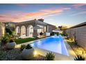 Stunning backyard with a pool, lounge chairs, manicured landscaping, and outdoor seating at 38 Costa Tropical Dr, Henderson, NV 89011