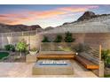 Inviting backyard seating area features a modern fire pit and integrated bench seating at 38 Costa Tropical Dr, Henderson, NV 89011
