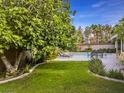Lush backyard featuring a green lawn, mature trees, and a refreshing swimming pool at 390 Rushing Creek Ct, Henderson, NV 89014