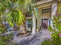 Inviting front porch with mature palms, seating, and meticulously maintained landscaping at 390 Rushing Creek Ct, Henderson, NV 89014