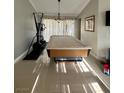 Large, bright recreation room with tile flooring and a pool table covered by a cloth at 390 Rushing Creek Ct, Henderson, NV 89014
