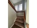 Carpeted stairs going up with a window at the landing and wooden handrails at 390 Rushing Creek Ct, Henderson, NV 89014