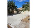 Exterior shot of the home with a spacious driveway and low-maintenance desert landscaping at 5305 Bright Sun Ct, Las Vegas, NV 89130