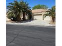 Charming single-story home with a three-car garage and mature palm trees in a desert landscape at 5305 Bright Sun Ct, Las Vegas, NV 89130