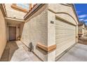 Close-up of townhome entrance featuring front door and an attached two-car garage at 5330 E Charleston Blvd # 28, Las Vegas, NV 89142