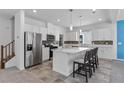 Bright kitchen features stainless steel appliances, an island with seating, and sleek white cabinetry at 5937 W Frias Ave, Las Vegas, NV 89141