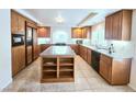 Large kitchen with an island, granite countertops, tiled floors, and wood cabinets at 6269 Bold Regatta Ct, Las Vegas, NV 89139