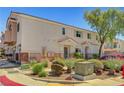 Pleasant exterior view of townhomes with neat landscaping and neutral color palette at 6433 Buck Jones Ave # 102, Las Vegas, NV 89122