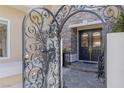 An ornate iron gate opens to a beautiful double door entry with stone steps and lush landscaping at 712 Proud Eagle Ln, Las Vegas, NV 89144