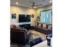 Comfortable living room featuring a ceiling fan, hardwood floors, a flat screen tv, and stylish decor at 740 Omaggio Pl, Henderson, NV 89011