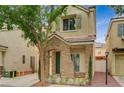Inviting front exterior featuring a stone facade, desert landscaping, and shade tree at 8261 Golden Flowers St, Las Vegas, NV 89139