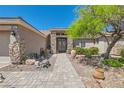 Stunning home entrance features stone accents, mature landscaping, and a welcoming walkway at 8325 Villa De Medici St, Las Vegas, NV 89131