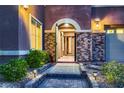 Inviting front entrance with stone accents, decorative lighting, and a charming walkway at 8705 Killians Greens Dr, Las Vegas, NV 89131