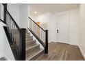 Bright foyer features wood flooring and a staircase with metal and dark wood banister at 881 Cherry Glen Pl, Las Vegas, NV 89138