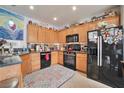 Well-lit kitchen with ample wooden cabinets, modern black appliances, and a granite countertop, ready for cooking at 9412 Jewel Lake Ave, Las Vegas, NV 89166