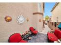 Cozy patio space adorned with sun-shaped wall decor and inviting red seating, perfect for outdoor relaxation at 9412 Jewel Lake Ave, Las Vegas, NV 89166