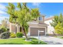 Well-maintained two-story home with a two-car garage and landscaped front yard offers curb appeal at 9465 Perennial View Ave, Las Vegas, NV 89148