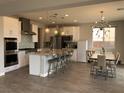 Open concept kitchen and dining area featuring a large island and modern lighting fixtures at 1064 Blue Wine Ct, Henderson, NV 89002