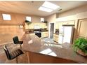 A kitchen featuring neutral cabinets, granite countertops, tile floors, and a skylight for ample natural lighting at 10717 Grand Cypress Ave, Las Vegas, NV 89134