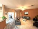 A spacious living room with tile floors, a ceiling fan, and neutral paint, and a comfortable seating arrangement at 10717 Grand Cypress Ave, Las Vegas, NV 89134