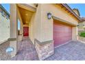 Close-up of home showcasing brick accents, a red door, and a matching brick driveway at 10979 Bristol Park Ave, Las Vegas, NV 89166