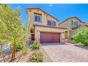 Inviting two-story home featuring manicured landscaping and a brick driveway, offering curb appeal at 10979 Bristol Park Ave, Las Vegas, NV 89166